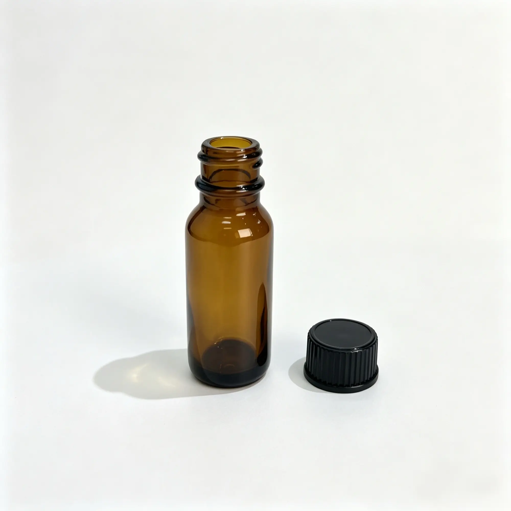 15ml Euro Dropper Essential Oil Bottle and Black Cap Uncapped 15ml Euro dropper essential oil bottle displayed beside its black flat screw cap