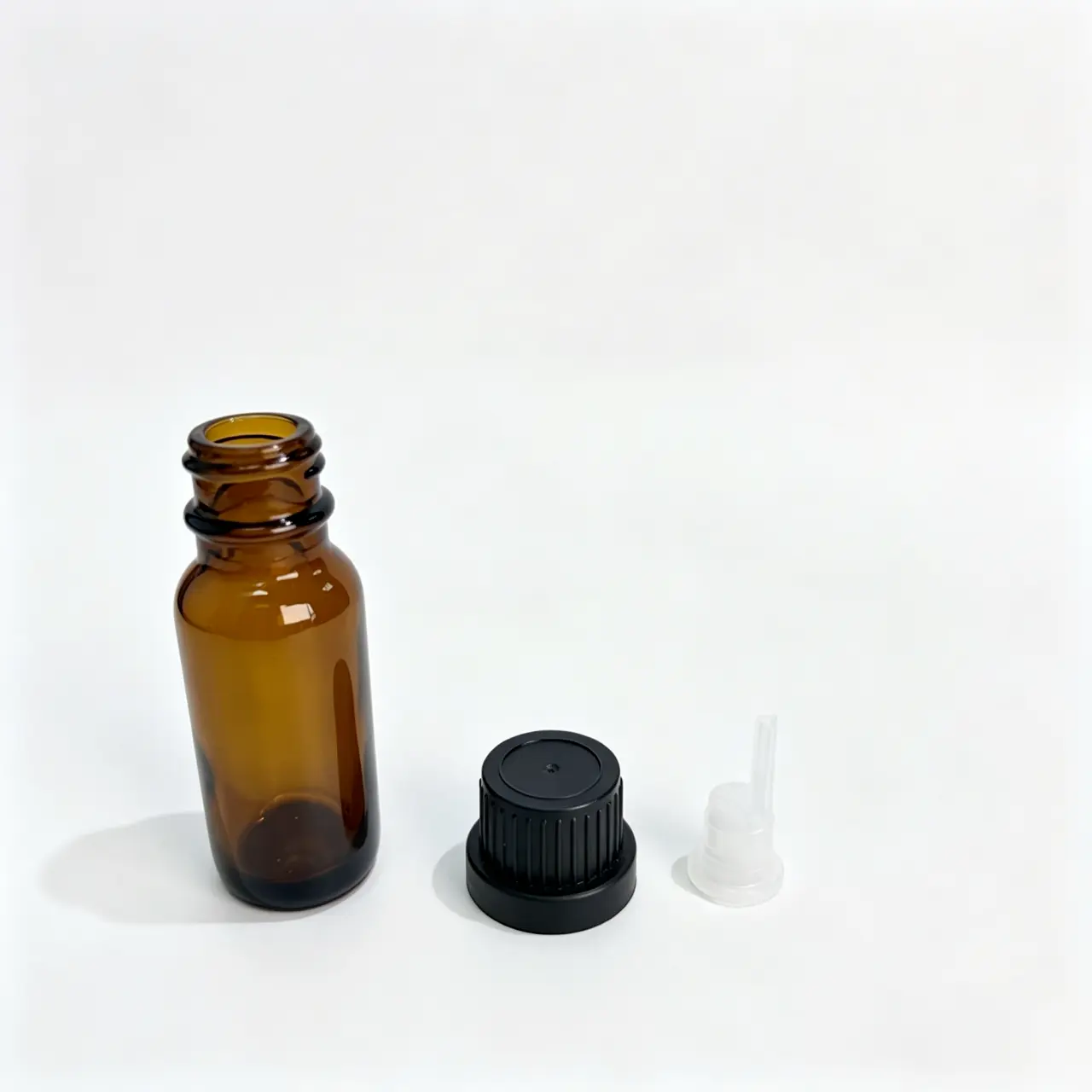 Uncapped 30ml Euro dropper essential oil bottle displayed with the black screw cap and separate inner plug